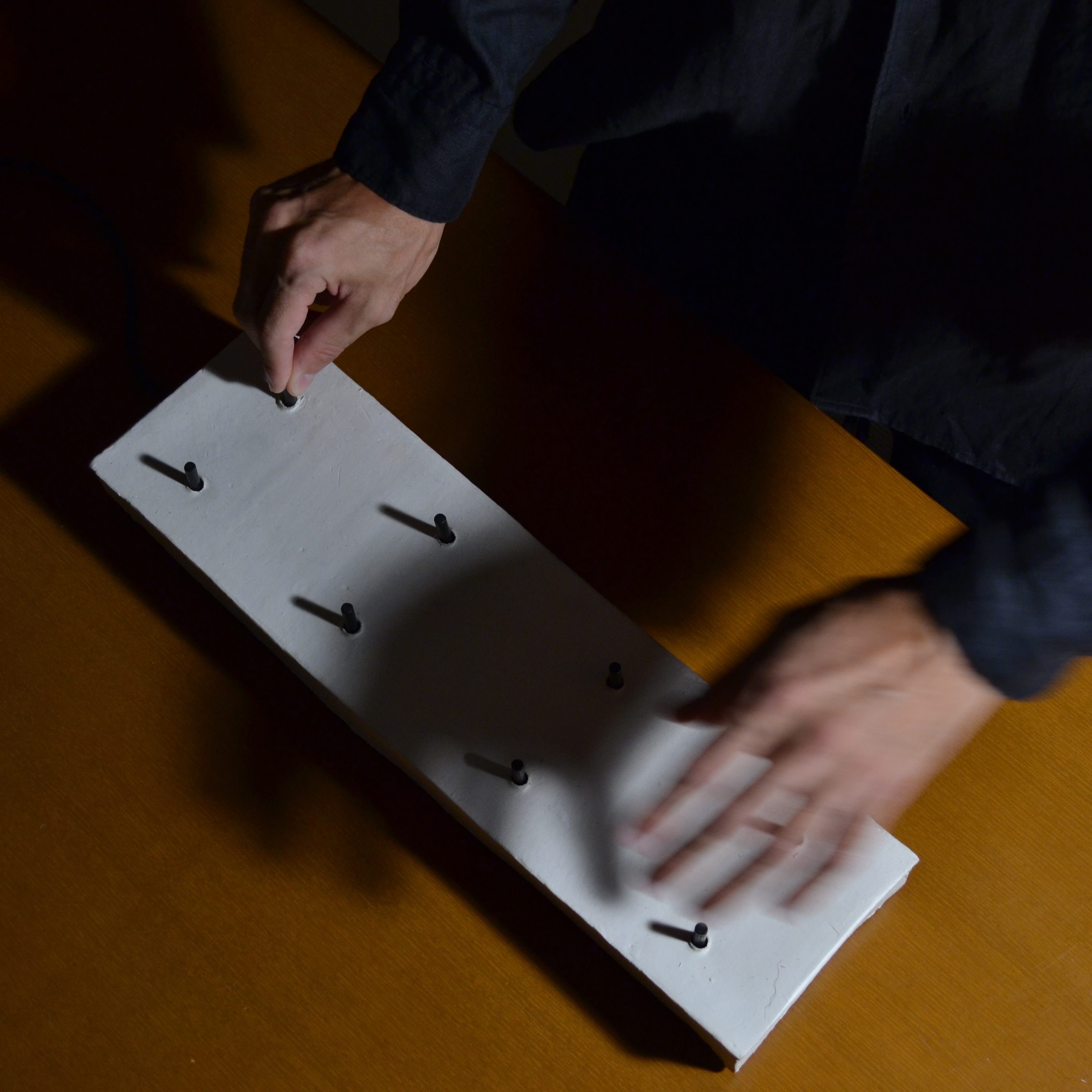 Close view of the performer's hands interacting with the controller's openings